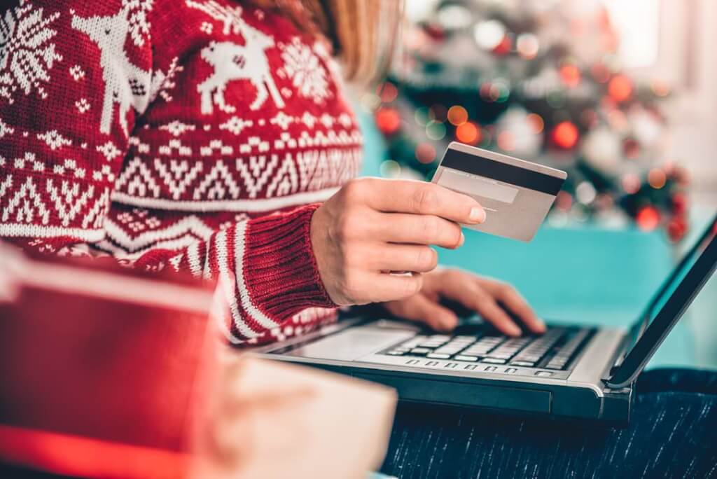 Kvinna med jultröja som shoppar online